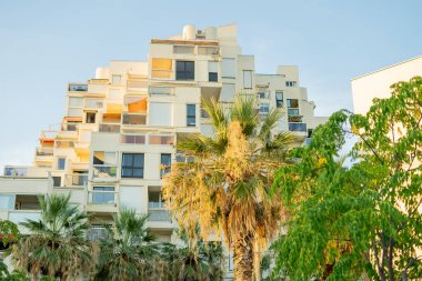 Deniz kenarında küçük bir Fransız kasabasının sokakları. Beyaz binalar, yollar, palmiye ağaçları.