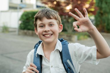 Sokakta sırt çantalı bir çocuğun portresi. Okula geri dön..