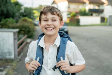 Sokakta sırt çantalı bir çocuğun portresi. Okula geri dön..