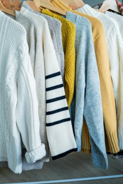 Askılarda sıcak, sıcak kıyafetler. Sonbahar süveteri ördüm. Örgüt.