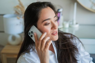 Genç bayan akıllı telefondan telefon görüşmesi yapıyor..