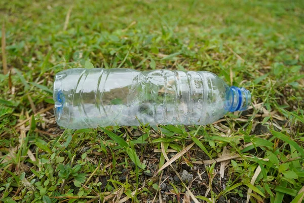 Plastic bottle waste in the middle of green grass nature close up