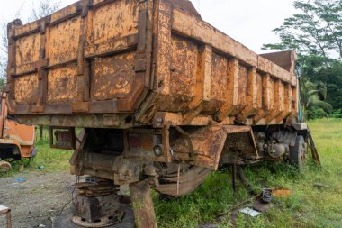 Abandoned broken trucks in the middle of nature covered in wild bushes close up
