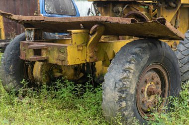 Abandoned broken trucks in the middle of nature covered in wild bushes close up