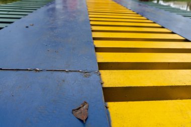 Colorful suspension bridge in the middle of a city park close up