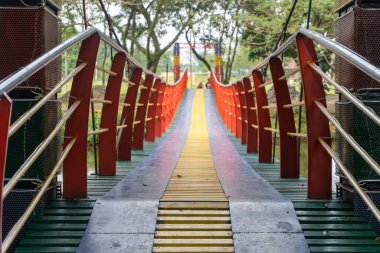 Colorful suspension bridge in the middle of a city park close up