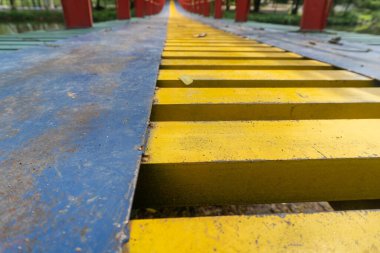 Colorful suspension bridge in the middle of a city park close up