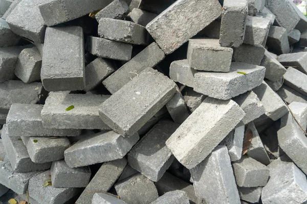 Pile of gray concrete bricks in the middle of a city park construction close up
