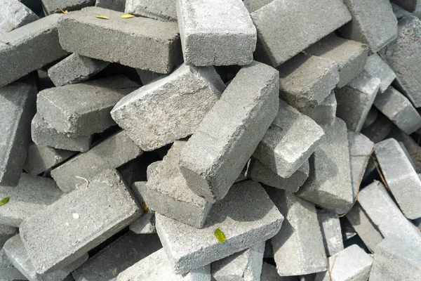 Pile of gray concrete bricks in the middle of a city park construction close up