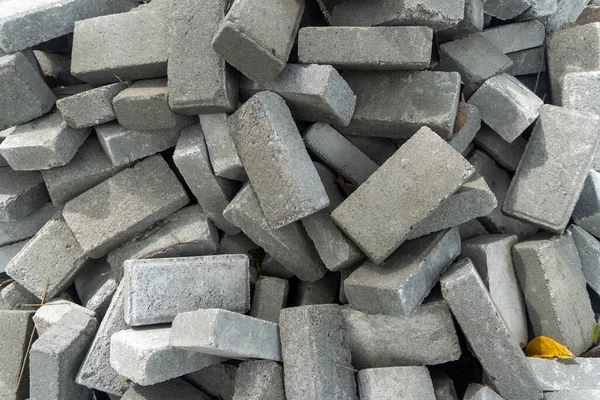 Pile of gray concrete bricks in the middle of a city park construction close up