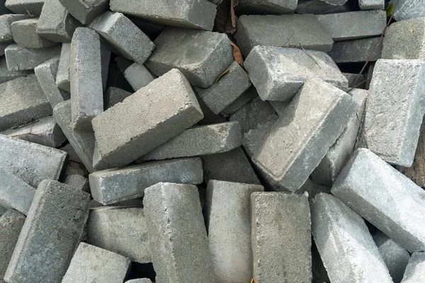 Pile of gray concrete bricks in the middle of a city park construction close up