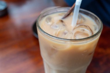 iced milk drink on a wooden table inside the cafe close up