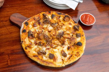 Pizza food on wooden table inside cafe close up