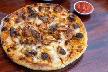 Pizza food on wooden table inside cafe close up