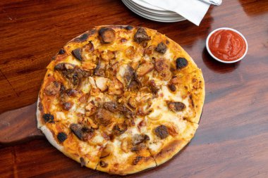 Pizza food on wooden table inside cafe close up