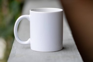 Bulanık arkaplanı olan beyaz seramik kahve kupası.