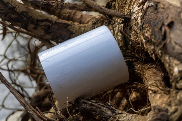 A close-up photo of a white mug in a peaceful park setting, showcasing the beauty and serenity of taking a break surrounded by nature