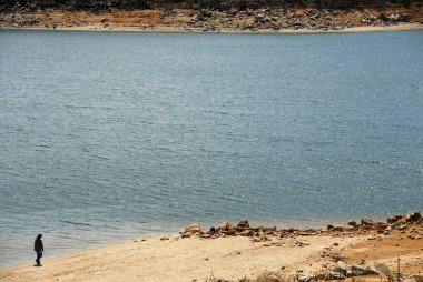 Jindabyne, New South Wales, Avustralya: Göl kıyısında yürüyen bir kadınla Jindabyne Gölü manzarası. Jindabyne, Karlı Dağlar yakınlarında bir turizm merkezidir..