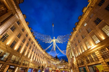 Londra, İngiltere 'de Regent Caddesi boyunca mimarlık. Regent Caddesi 'nin akşam manzarası. Yolun üstünde Noel ışıkları var..