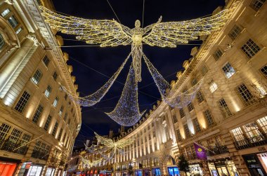 Londra, İngiltere 'de Regent Caddesi boyunca mimarlık. Regent Caddesi 'nin akşam manzarası. Yolun üstünde Noel ışıkları var..