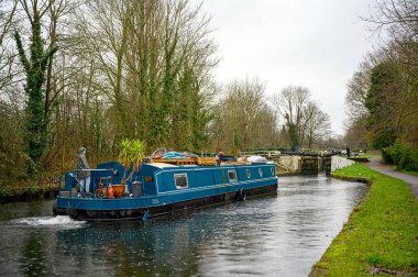 Hanwell Locks on the Grand Union Canal at Hanwell, London, UK. A canal boat about to pass through lock number 96 at the Hanwell Flight of Locks seen in the rain.