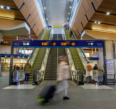 Londra Köprüsü tren istasyonunda hareket bulanıklığı olan insanlar. İstasyon, yürüyen merdivenlerle platformlara. Londra Köprü İstasyonu, Londra 'da bir nakliye merkezidir..