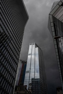 Londra, İngiltere: 22 Bishopsgate veya TwentyTwo karanlık, dönen fırtına bulutlarına karşı gökyüzünü yansıtıyor. Dramatik Londra sahnesi 100 Bishopsgate (L) ve 99 Bishopsgate (R).