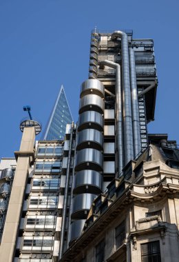 Londra, İngiltere - 14 Haziran 2023: The Lloyds of London binası arkasında The Scalpel 'in sivri uçlu kulesi. Londra 'daki Leadenhall Caddesi' nden görüldü..