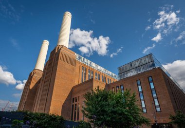 Battersea, Londra, İngiltere: Battersea Enerji İstasyonu şimdi bir alışveriş ve eğlence merkezi olarak yeniden geliştirildi. Önplanda ağaç olan manzara görünümü.