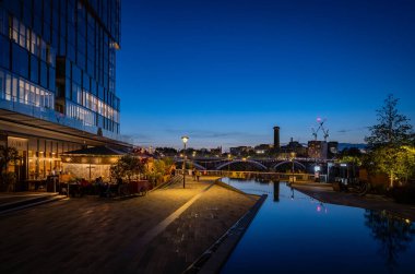 Battersea, Londra, İngiltere: Battersea Enerji İstasyonu yakınlarındaki bir park ve restoranda göletler. Chelsea 'nin güneyine bakan gece manzarası.