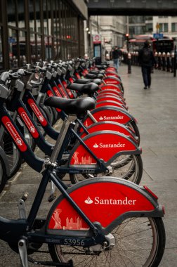 Londra, İngiltere: Londra 'daki Blackfriars istasyonunun yanındaki Queen Victoria Caddesi' nde bisiklet kiralama istasyonu. Santander sponsorluğundaki bu bisikletler daha önce Boris Bisikletleri olarak biliniyordu..