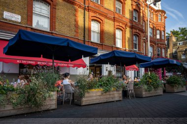 Londra, İngiltere: Güney Kensington, Londra 'daki Exhibition Road. İnsanlar Güney Kensington metro istasyonuna yakın bir restoranda oturuyorlar..
