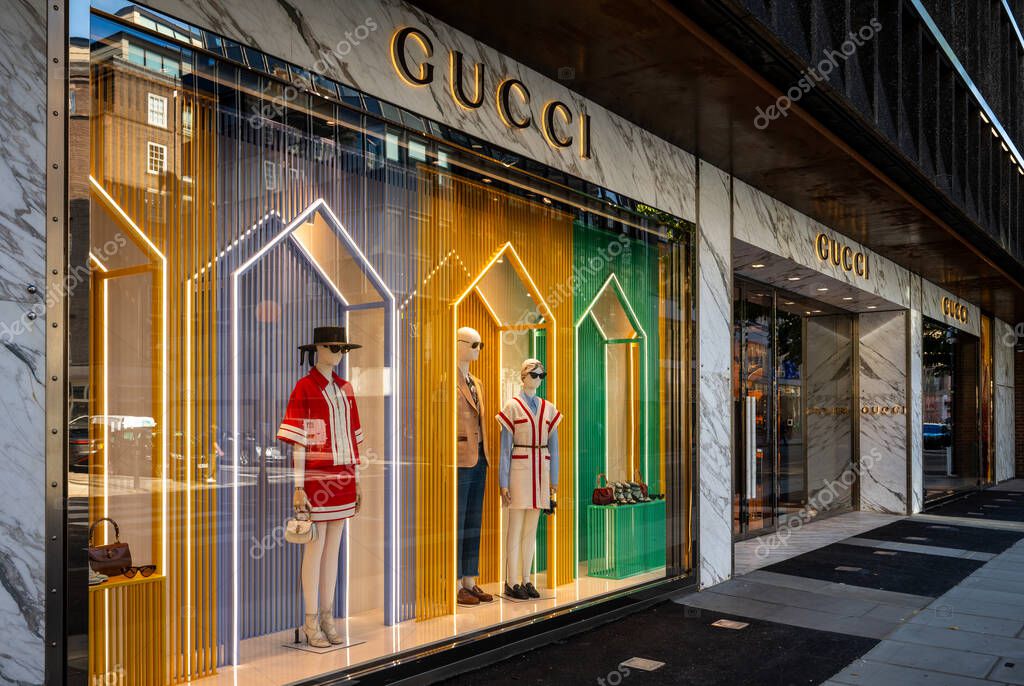London, UK: Gucci store on Sloane Street in Knightsbridge, London. Colorful window display with mannequins displaying luxury fashion items.