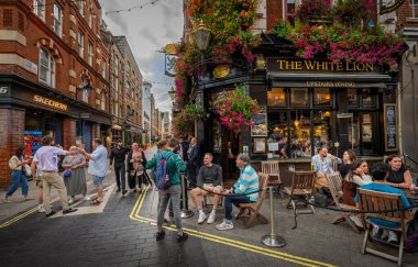 Floral Street ve James Street 'in köşesindeki White Lion barının dışındaki insanlar. Londra 'nın batı ucundaki Covent Garden' da..