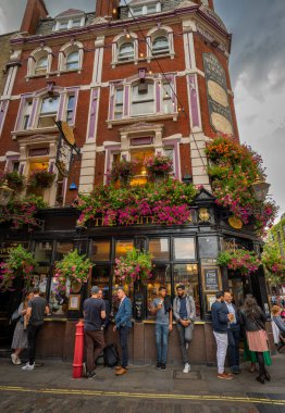 Floral Street ve James Street 'in köşesindeki White Lion barının dışındaki insanlar. Londra 'nın batı ucundaki Covent Garden' da..