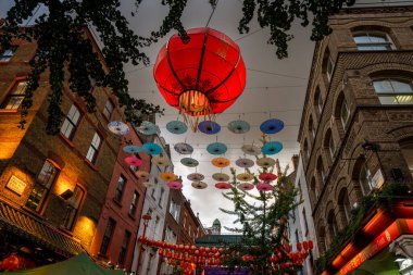 Londra, İngiltere: Londra 'nın Çin Mahallesi' ndeki Gerard Caddesi ve Macclesfield Caddesi kavşağı. Kırmızı Çin fenerleri ve renkli şemsiyeler sokağın üstünde asılı..