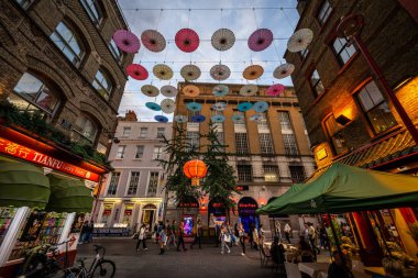 Londra, İngiltere: Londra 'nın Çin Mahallesi' ndeki Gerard Caddesi ve Macclesfield Caddesi kavşağı. Kırmızı Çin fenerleri ve renkli şemsiyeler sokağın üstünde asılı..