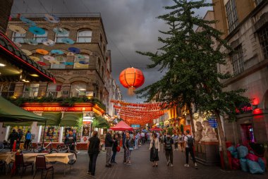 Londra, İngiltere: Londra 'nın Çin Mahallesi' ndeki Gerard Caddesi ve Macclesfield Caddesi kavşağı. Kırmızı Çin fenerleri ve renkli şemsiyeler sokağın üstünde asılı..