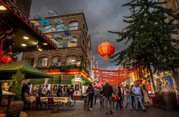 Londra, İngiltere: Londra 'nın Çin Mahallesi' ndeki Gerard Caddesi ve Macclesfield Caddesi kavşağı. Kırmızı Çin fenerleri ve renkli şemsiyeler sokağın üstünde asılı..