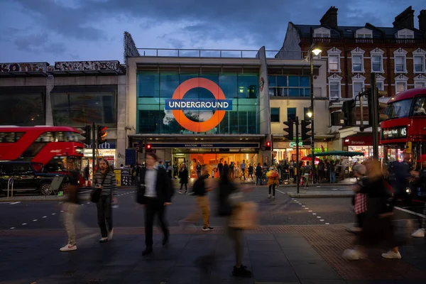 Brixton, Londra, İngiltere Brixton Caddesi 'ndeki yaya geçidi Brixton metro istasyonunun karşısında. İnsanlarla akşam manzarası ve kırmızı Londra otobüsleri..