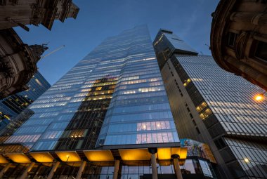 Londra, İngiltere: 22 Bishopsgate veya TwentyTwo ve 8 Bishopsgate, Londra 'da ofis ışıklarıyla. Direk aşağıdan yukarı bakıyor ve diğer binalar tarafından çerçeveleniyor..
