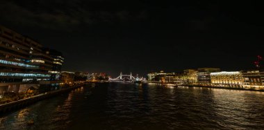 Londra Köprüsü 'nden çekilen Thames Nehri üzerindeki gece görüşü açık bir Tower Köprüsü' ne doğru bakıyor. Geniş açı panoraması.