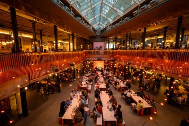 London, UK: Seven Dials Market in the Covent Garden area of central London. People are eating and drinking in the food hall. clipart