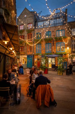 Londra, İngiltere: Londra 'nın merkezindeki Covent Garden bölgesinde Neal' s Yard. İnsanlar akşam bir restoranın önünde oturuyorlar..