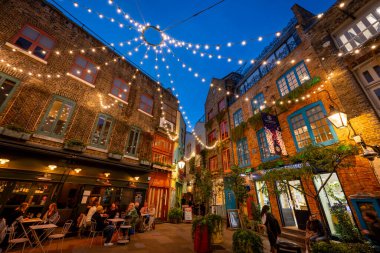 Londra, İngiltere: Londra 'nın merkezindeki Covent Garden bölgesinde Neal' s Yard. İnsanlar akşam bir restoranın önünde oturuyorlar..