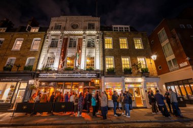 Londra, İngiltere: Londra 'nın merkezindeki Covent Garden bölgesinde Seven Dials yakınlarında Monmouth Caddesi. Gece yarısı Two Brewers barının önünde insanlar..