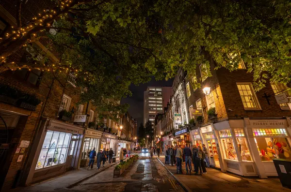 Londra, İngiltere: Londra 'nın merkezindeki Covent Garden bölgesinde Seven Dials yakınlarında Monmouth Caddesi. Geceleri sokaktaki insanlar.