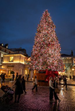 Londra, İngiltere - 8 Kasım 2023: Covent Garden Market 'in dışındaki büyük süslü Noel ağacı. Portre yönelimi.