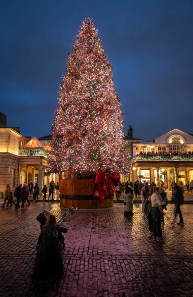 Londra, İngiltere - 8 Kasım 2023: Covent Garden Market 'in dışındaki büyük süslü Noel ağacı. Portre yönelimi.