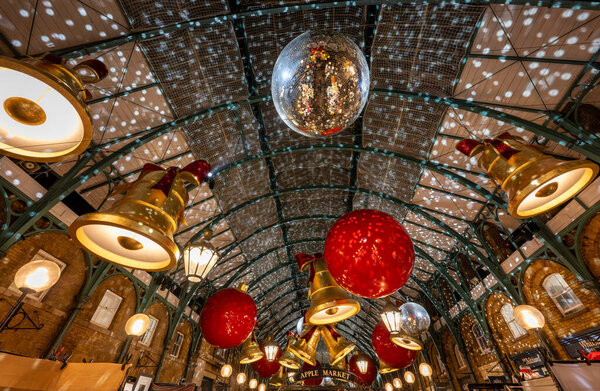 London, UK - Nov 8 2023: Covent Garden Market with Christmas decorations. Large bells and baubles hang from the roof.
